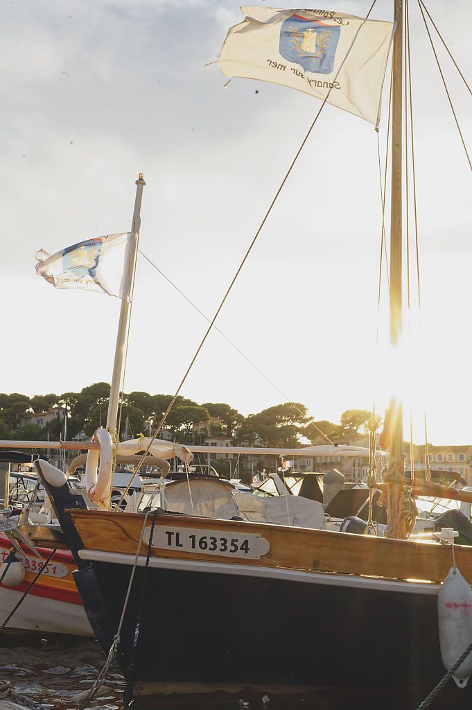 Un pointu et ses fanions dans le port, au soleil couchant