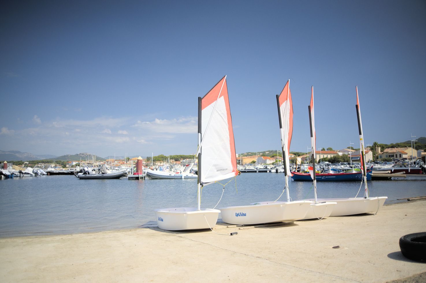 Petits voiliers d'école tirés sur la plage, au bord de l'eau